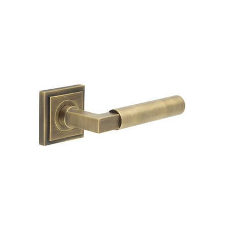 This is an image showing the Frelan - Westminster Door Handle on Square Stepped Rose Antique Brass available to order from T.H. Wiggans Ironmongery in Kendal