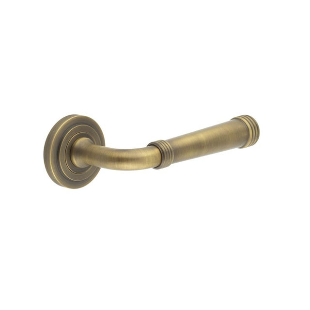 This is an image showing the Frelan - Highgate Door Handles Stepped Rose Antique Brass available to order from T.H. Wiggans Ironmongery in Kendal