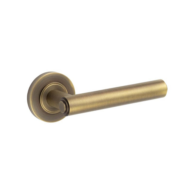 This is an image showing the Frelan - Richmond Door Handles Plain Rose Antique Brass available to order from T.H. Wiggans Ironmongery in Kendal