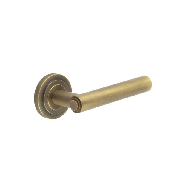 This is an image showing the Frelan - Richmond Door Handles Stepped Rose Antique Brass available to order from T.H. Wiggans Ironmongery in Kendal