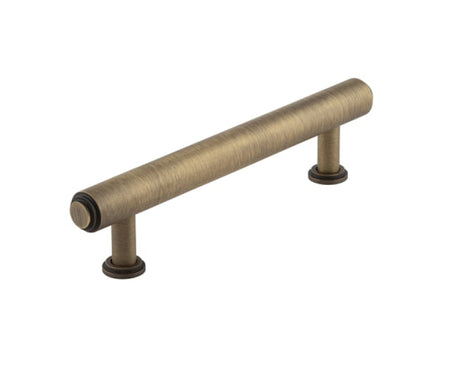 This is an image showing the Burlington - Belgrave Cabinet Handle 128mm CTC - Antique Brass available to order from T.H. Wiggans Ironmongery in Kendal