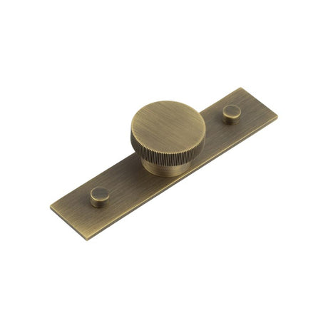 This is an image showing the Frelan - Thaxted Cupboard Knobs 40mm Plain Backplate Antique Brass available to order from T.H. Wiggans Ironmongery in Kendal