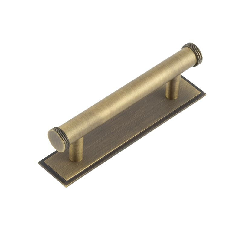 This is an image showing the Frelan - Hoxton Thaxted Cabinet Handles 96mm Ctrs Stepped Backplate Antique Brass available to order from T.H. Wiggans Ironmongery in Kendal