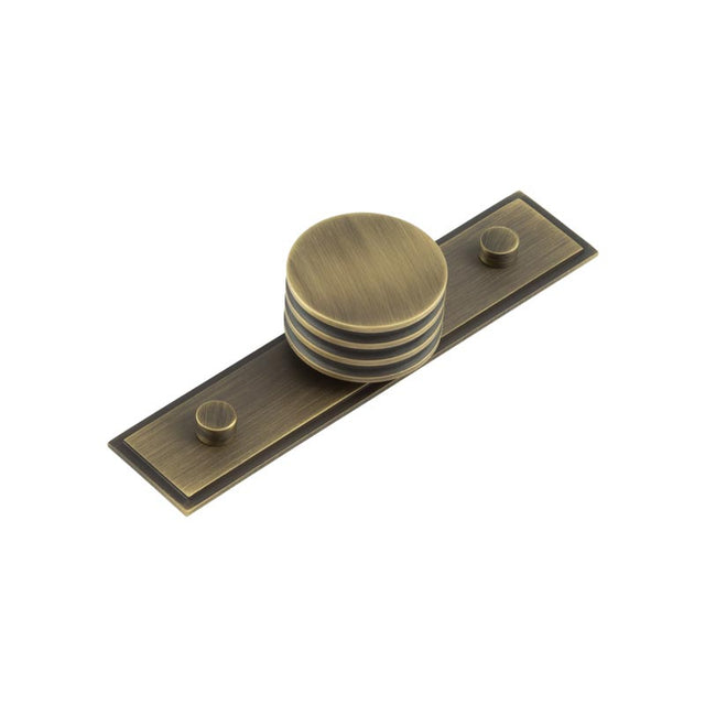 This is an image showing the Frelan - Sturt Cupboard Knobs 40mm Stepped Antique Brass available to order from T.H. Wiggans Ironmongery in Kendal