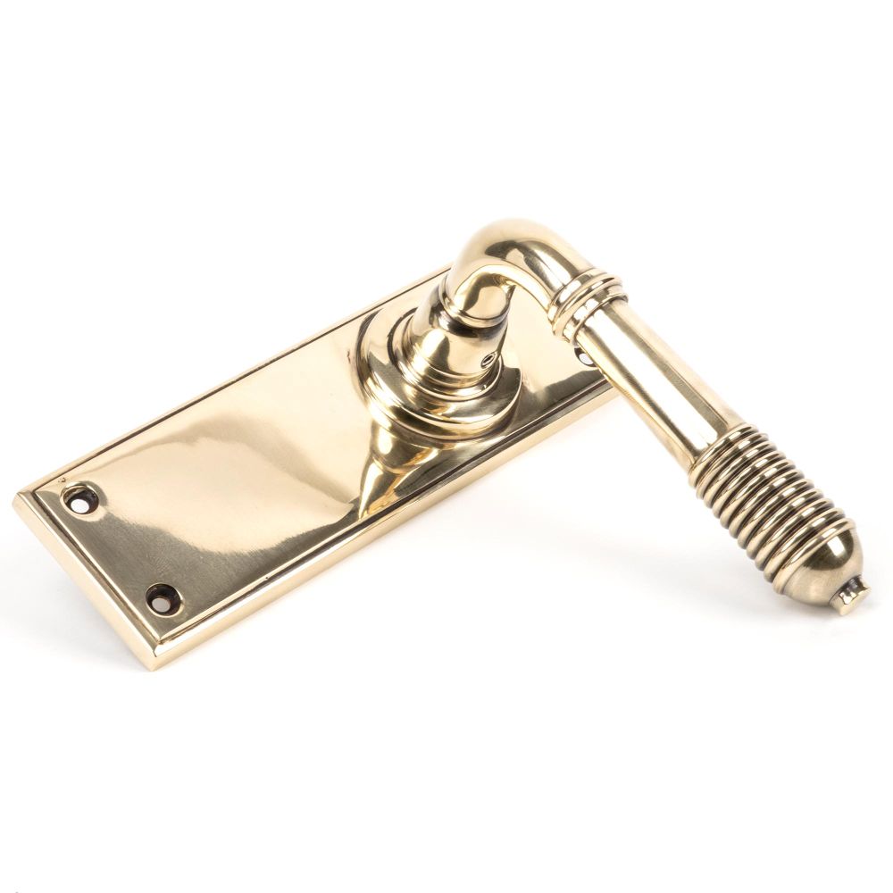 This is an image showing From The Anvil - Aged Brass Reeded Lever Latch Set available from trade door handles, quick delivery and discounted prices