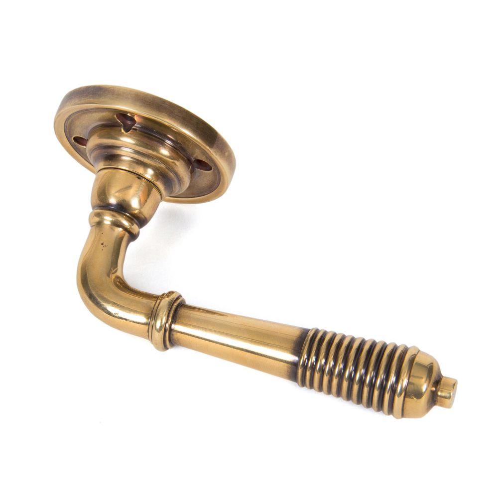 This is an image showing From The Anvil - Aged Brass Reeded Lever on Rose Set available from trade door handles, quick delivery and discounted prices