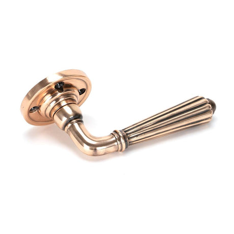 This is an image showing From The Anvil - Polished Bronze Hinton Lever on Rose Set available from trade door handles, quick delivery and discounted prices