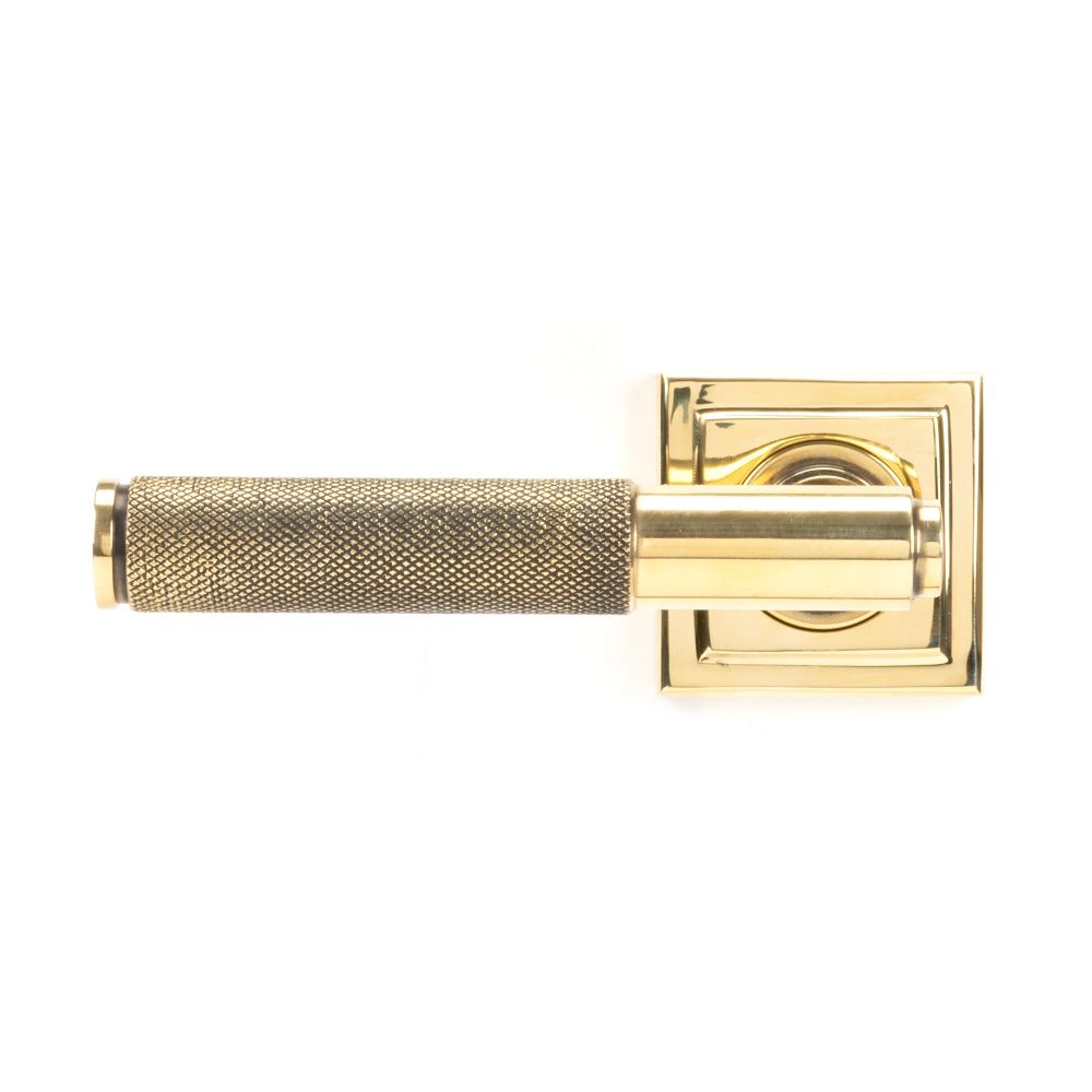 This is an image showing From The Anvil - Aged Brass Brompton Lever on Rose Set (Square) available from trade door handles, quick delivery and discounted prices