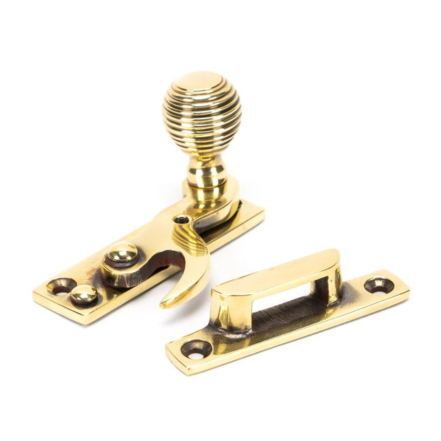 This is an image showing From The Anvil - Aged Brass Beehive Sash Hook Fastener available from T.H Wiggans Architectural Ironmongery in Kendal, quick delivery and discounted prices