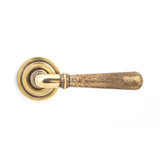 This is an image showing From The Anvil - Aged Brass Hammered Newbury Lever on Rose Set (Art Deco) available from trade door handles, quick delivery and discounted prices