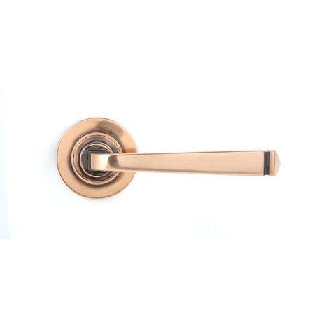 This is an image showing From The Anvil - Polished Bronze Avon Round Lever on Rose Set (Plain) available from trade door handles, quick delivery and discounted prices