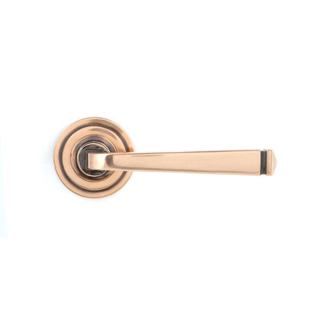 This is an image showing From The Anvil - Polished Bronze Avon Round Lever on Rose Set (Art Deco) available from trade door handles, quick delivery and discounted prices