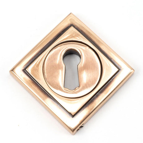 This is an image showing From The Anvil - Polished Bronze Round Escutcheon (Square) available from trade door handles, quick delivery and discounted prices