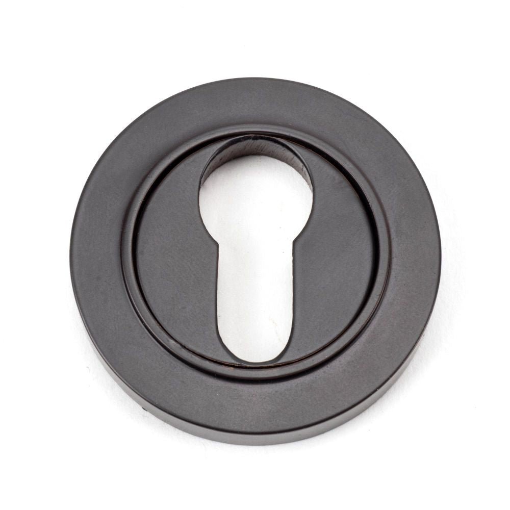 This is an image of From The Anvil - Aged Bronze Round Euro Escutcheon (Plain) available to order from T.H Wiggans Architectural Ironmongery in Kendal, quick delivery and discounted prices.