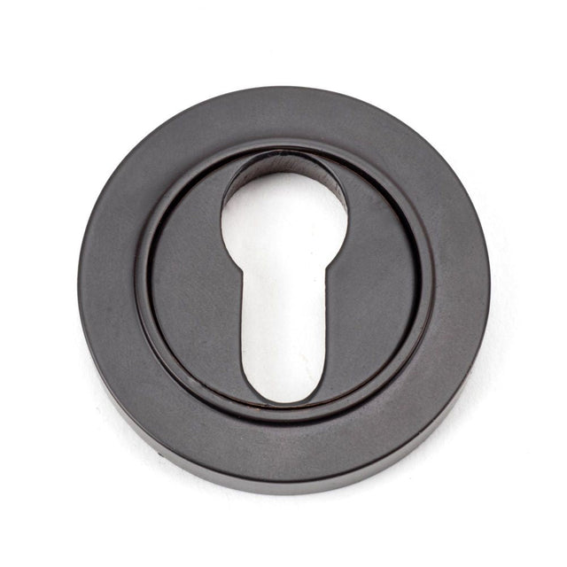 This is an image of From The Anvil - Aged Bronze Round Euro Escutcheon (Plain) available to order from T.H Wiggans Architectural Ironmongery in Kendal, quick delivery and discounted prices.