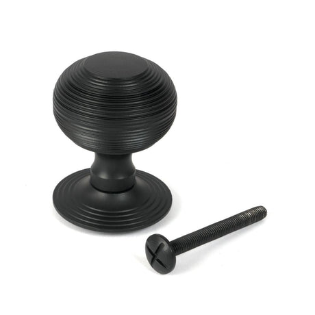 This is an image showing From The Anvil - Matt Black Beehive Centre Door Knob available from trade door handles, quick delivery and discounted prices