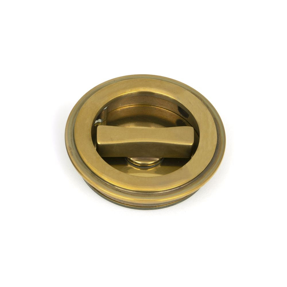 This is an image showing From The Anvil - Aged Brass 60mm Art Deco Round Pull - Privacy Set available from trade door handles, quick delivery and discounted prices