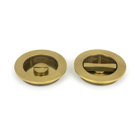 This is an image of From The Anvil - Aged Brass 75mm Art Deco Round Pull - Privacy Set available to order from T.H Wiggans Architectural Ironmongery in Kendal, quick delivery and discounted prices.