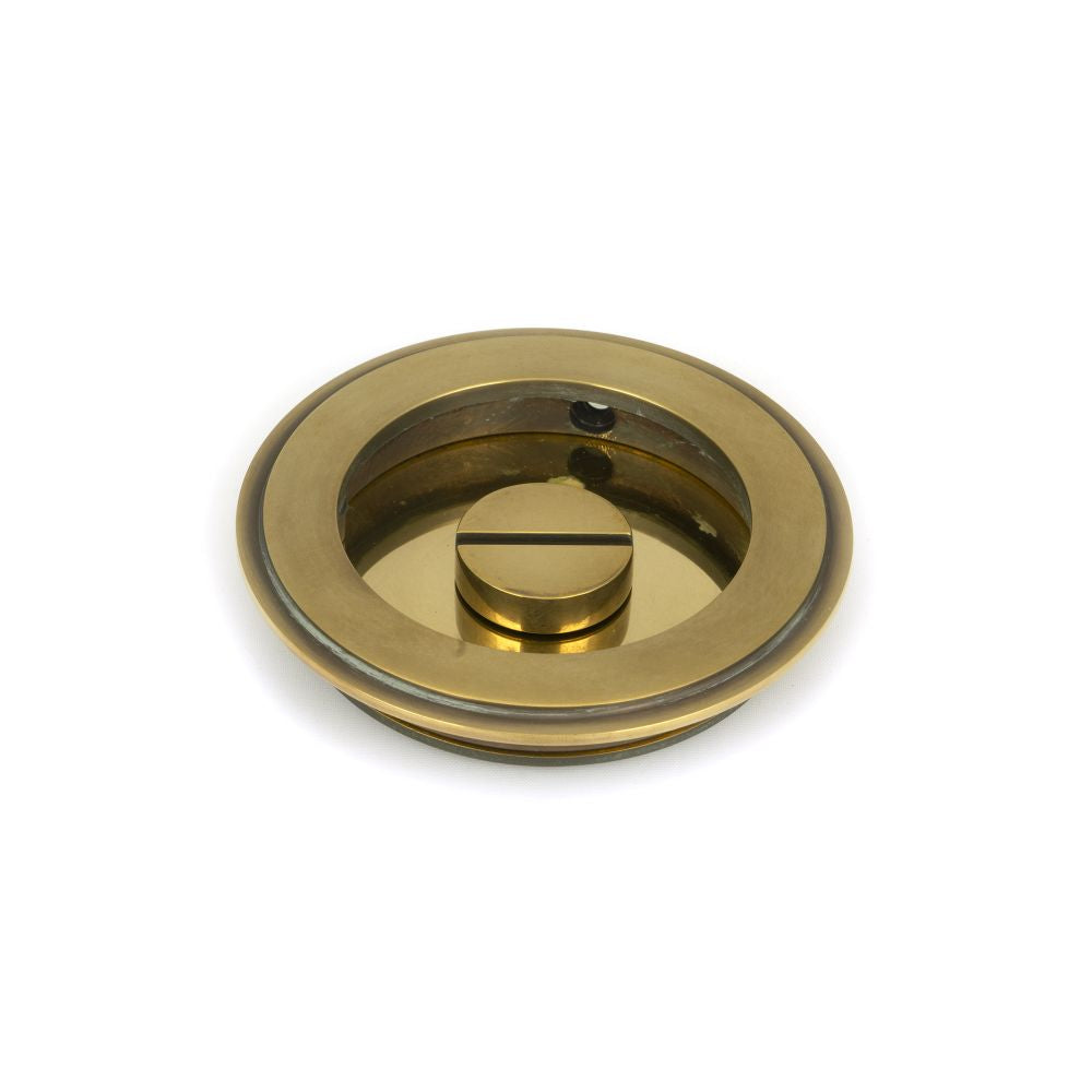 This is an image showing From The Anvil - Aged Brass 75mm Plain Round Pull - Privacy Set available from trade door handles, quick delivery and discounted prices