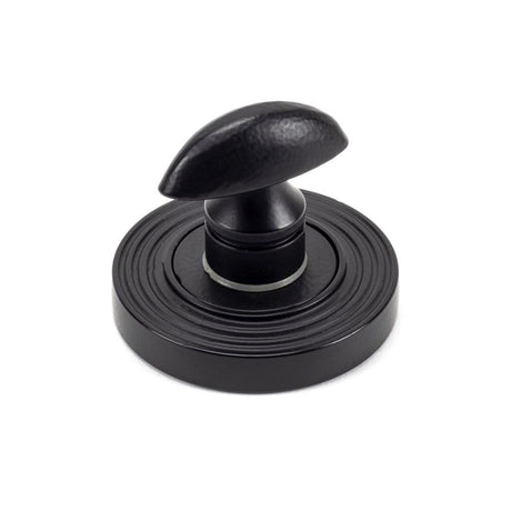 This is an image showing From The Anvil - Matt Black Round Thumbturn Set (Beehive) available from trade door handles, quick delivery and discounted prices