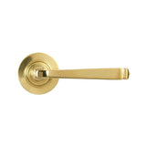 This is an image showing From The Anvil - Polished Brass Avon Round Lever on Rose Set (Plain) available from trade door handles, quick delivery and discounted prices