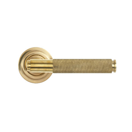 This is an image showing From The Anvil - Polished Brass Brompton Lever on Rose Set (Art Deco) - Unsprung available from trade door handles, quick delivery and discounted prices