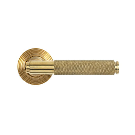 This is an image showing From The Anvil - Polished Brass Brompton Lever on Rose Set (Beehive) - Unsprung available from trade door handles, quick delivery and discounted prices