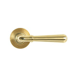 This is an image showing From The Anvil - Polished Brass Newbury Lever on Rose Set (Beehive) available from trade door handles, quick delivery and discounted prices