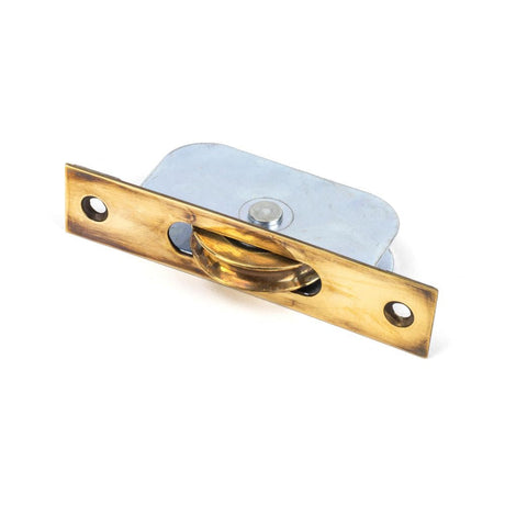 This is an image showing From The Anvil - Aged Brass Square Ended Sash Pulley 75kg available from T.H Wiggans Architectural Ironmongery in Kendal, quick delivery and discounted prices