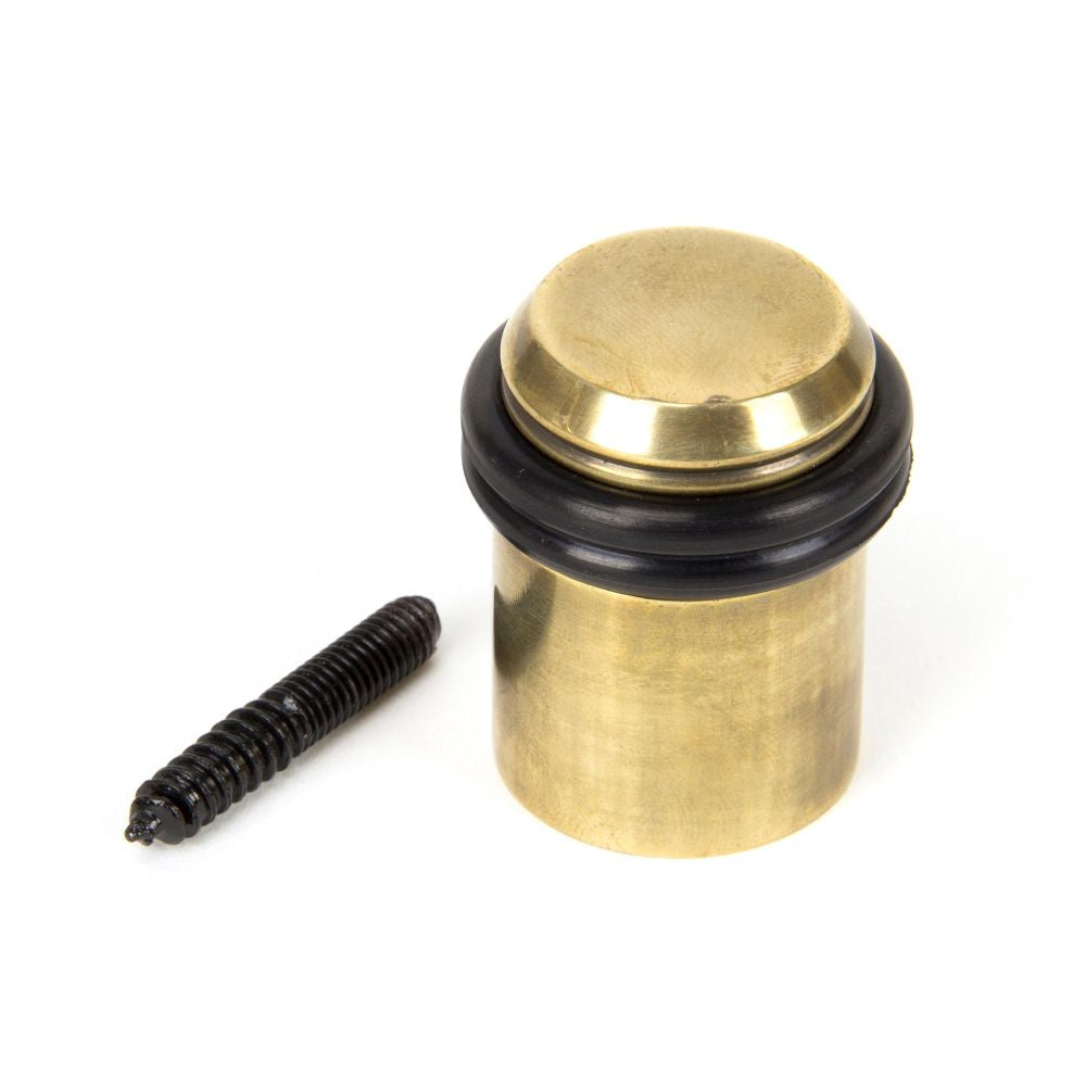 This is an image showing From The Anvil - Aged Brass Floor Mounted Door Stop available from trade door handles, quick delivery and discounted prices