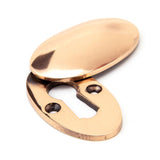 This is an image showing From The Anvil - Polished Bronze Oval Escutcheon & Cover available from trade door handles, quick delivery and discounted prices