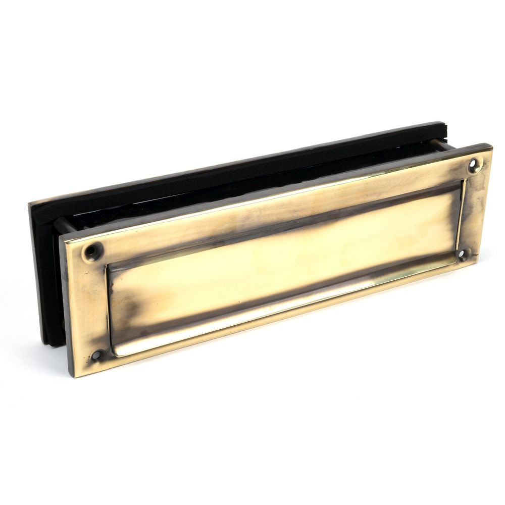 This is an image showing From The Anvil - Aged Brass Traditional Letterbox available from trade door handles, quick delivery and discounted prices