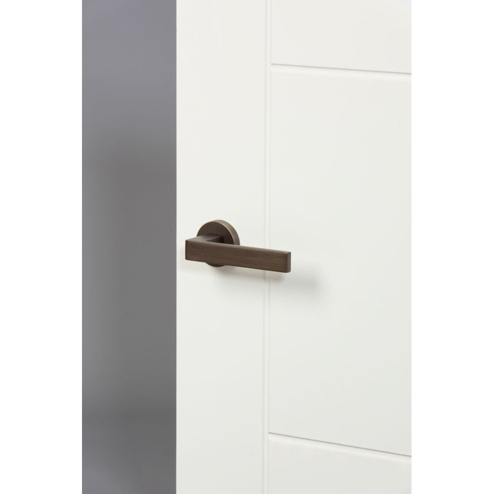 This is an image of Forme Asti Designer Lever on Minimal Round Rose - Urban Bronze available to order from T.H Wiggans Architectural Ironmongery in Kendal, quick delivery and discounted prices.