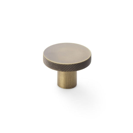 This is an image showing Alexander & Wilks Hanover Knurled Circular Cupboard Knob - Antique Brass - 38mm aw802-38-ab available to order from T.H Wiggans Ironmongery in Kendal, quick delivery and discounted prices.