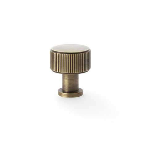 This is an image showing Alexander & Wilks Lucia Reeded Cupboard Knob - Antique Brass - 29mm aw807r-29-ab available to order from T.H Wiggans Ironmongery in Kendal, quick delivery and discounted prices.