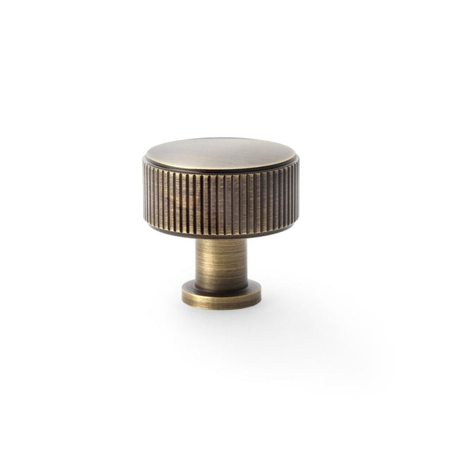 This is an image showing Alexander & Wilks Lucia Reeded Cupboard Knob - Antique Brass - 35mm aw807r-35-ab available to order from T.H Wiggans Ironmongery in Kendal, quick delivery and discounted prices.