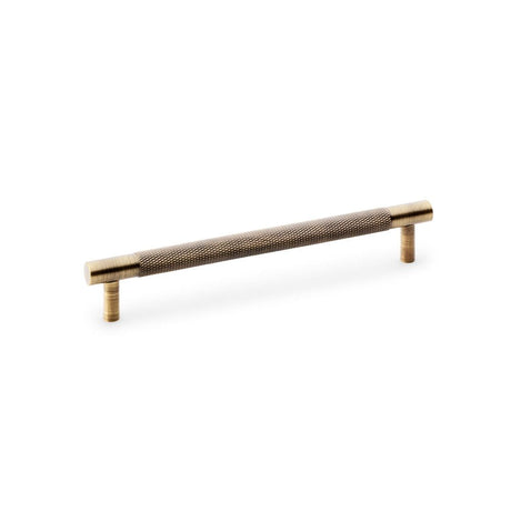 This is an image showing Alexander & Wilks Brunel Knurled T-Bar Cupboard Handle - Antique Brass - Centres 160mm aw810-160-ab available to order from T.H Wiggans Ironmongery in Kendal, quick delivery and discounted prices.