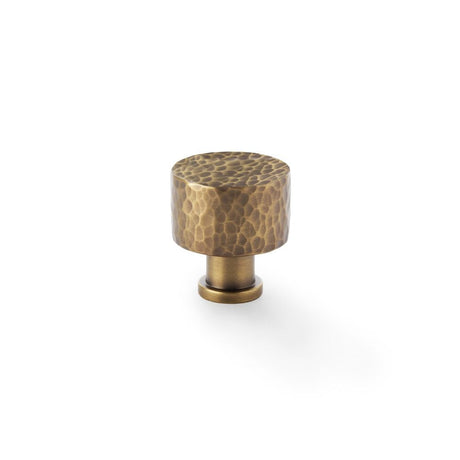 This is an image showing Alexander & Wilks Leila - Hammered Cupboard Knob - Antique Brass - 30mm aw816-30-ab available to order from T.H Wiggans Ironmongery in Kendal, quick delivery and discounted prices.