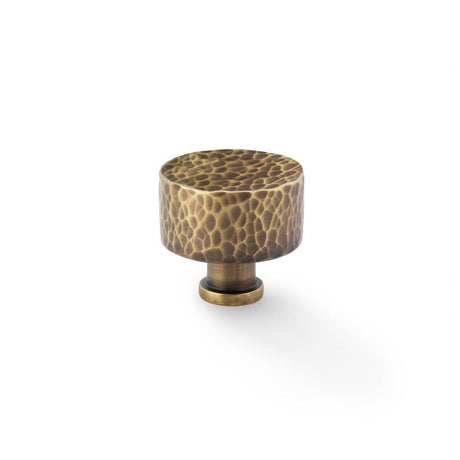 This is an image showing Alexander & Wilks Leila Hammered Cupboard Knob - Antique Brass - 35mm aw816-35-ab available to order from T.H Wiggans Ironmongery in Kendal, quick delivery and discounted prices.