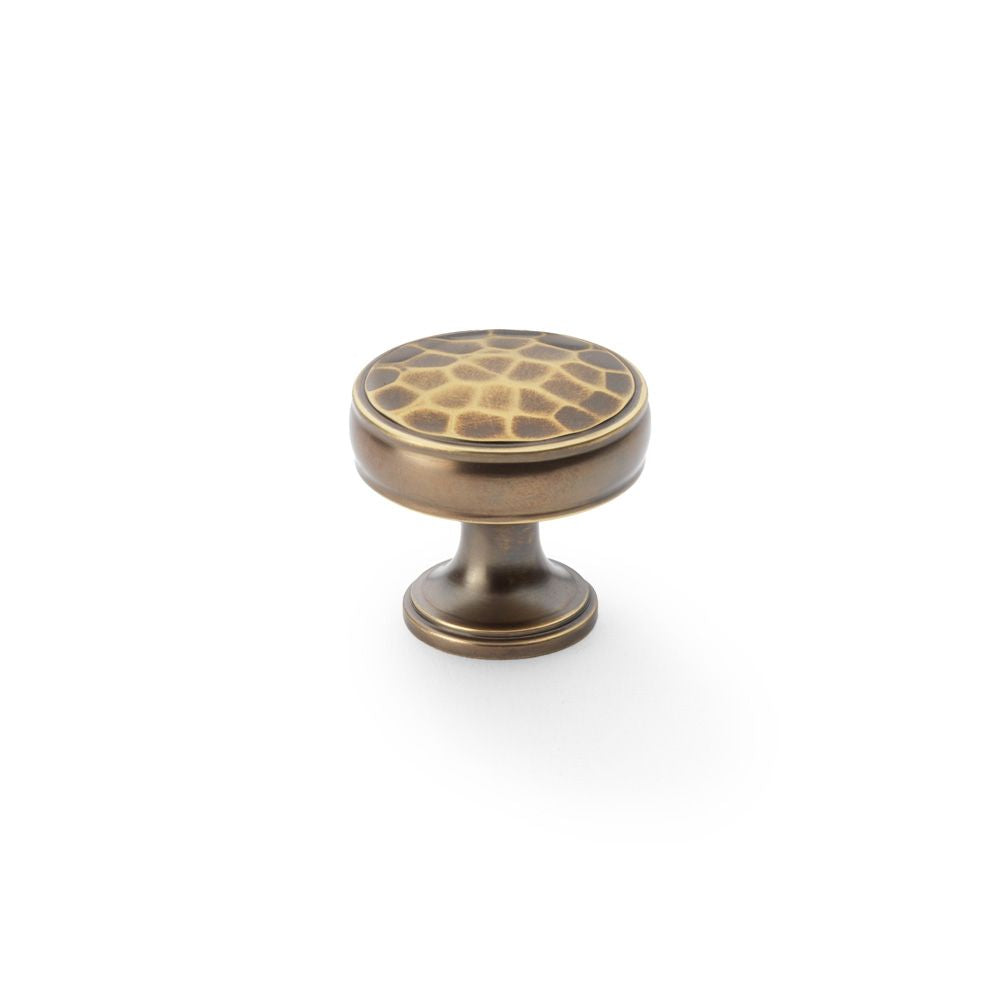 This is an image showing Alexander & Wilks Lynd Hammered Cupboard Knob - Antique Brass - 32mm aw818-32-ab available to order from T.H Wiggans Ironmongery in Kendal, quick delivery and discounted prices.