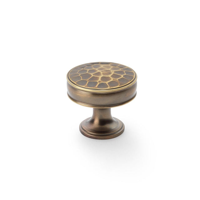 This is an image showing Alexander & Wilks Lynd Hammered Cupboard Knob - Antique Brass - 38mm aw818-38-ab available to order from T.H Wiggans Ironmongery in Kendal, quick delivery and discounted prices.