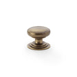 This is an image showing Alexander & Wilks Waltz Round Cupboard Knob on Stepped Rose - Antique Brass - 32mm aw825-32-ab available to order from T.H Wiggans Ironmongery in Kendal, quick delivery and discounted prices.