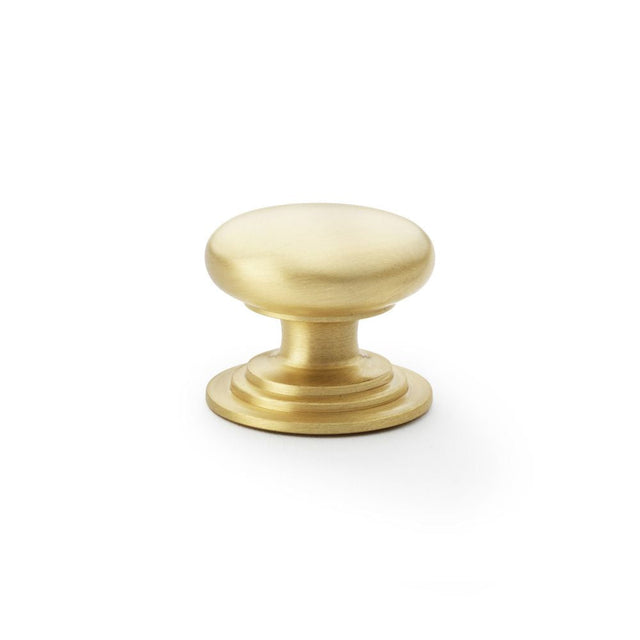 This is an image showing Alexander & Wilks Waltz Round Cupboard Knob on Stepped Rose - Satin Brass - 38mm aw825-38-sb available to order from T.H Wiggans Ironmongery in Kendal, quick delivery and discounted prices.