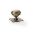 This is an image showing Alexander & Wilks Quantock Cupboard Knob on Square Backplate - Antique Brass - 34mm aw826-34-ab available to order from T.H Wiggans Ironmongery in Kendal, quick delivery and discounted prices.