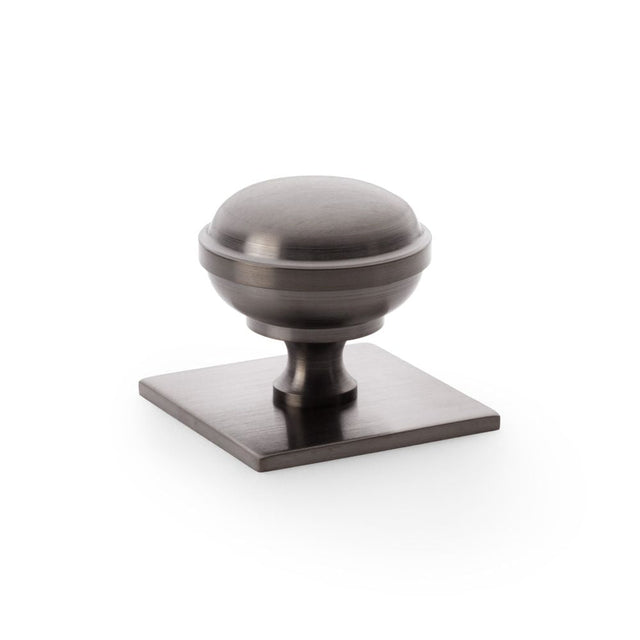 This is an image showing Alexander & Wilks Quantock Cupboard Knob on Square Backplate - Dark Bronze PVD - 38mm aw826-38-dbzpvd available to order from T.H Wiggans Ironmongery in Kendal, quick delivery and discounted prices.