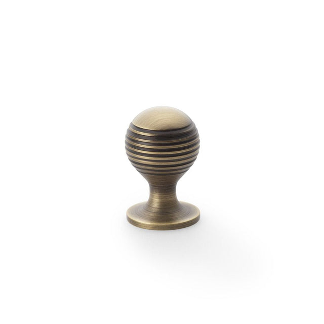 This is an image showing Alexander & Wilks Caesar Cupboard Knob on Round Rose - Antique Brass - 25mm aw832-25-ab available to order from T.H Wiggans Ironmongery in Kendal, quick delivery and discounted prices.