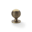 This is an image showing Alexander & Wilks Caesar Cupboard Knob on Round Rose - Antique Brass - 32mm aw832-32-ab available to order from T.H Wiggans Ironmongery in Kendal, quick delivery and discounted prices.