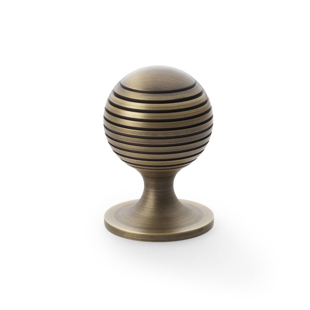 This is an image showing Alexander & Wilks Caesar Cupboard Knob on Round Rose - Antique Brass - 38mm aw832-38-ab available to order from T.H Wiggans Ironmongery in Kendal, quick delivery and discounted prices.