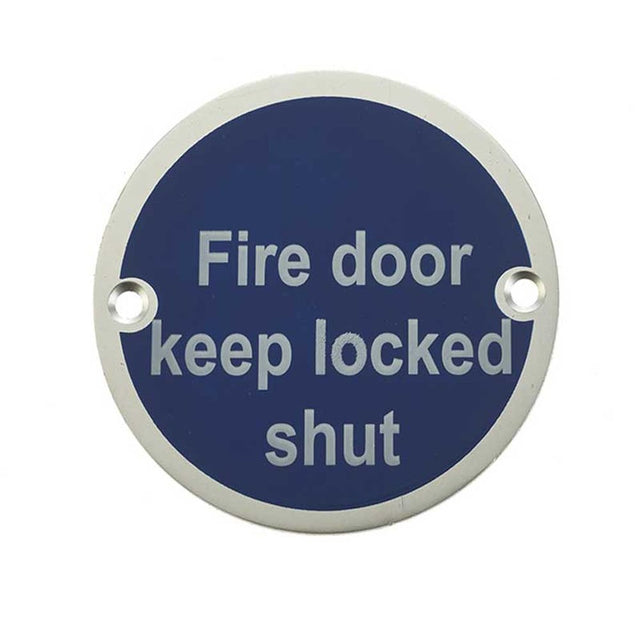 This is an image showing the Frelan - Fire Door Keep Locked Shut - Signage 75mm Dia. - Satin Anodised Alumini available to order from T.H. Wiggans Ironmongery in Kendal