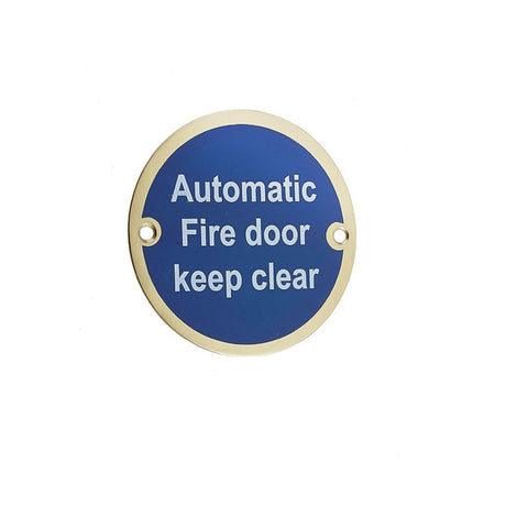 This is an image showing the Frelan - Automatic Fire Door Keep Clear - Signage 75mm Dia. - Polished Brass available to order from T.H. Wiggans Ironmongery in Kendal